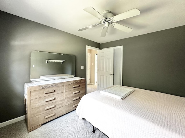 bedroom featuring light colored carpet, ceiling fan, and baseboards