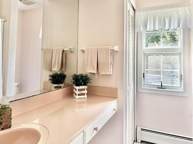 bathroom with a baseboard radiator, visible vents, and vanity