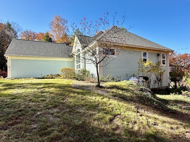 view of home's exterior featuring a yard and a shingled roof