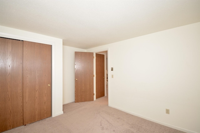 unfurnished bedroom featuring a closet, carpet flooring, and baseboards