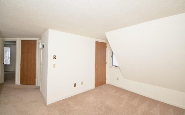 unfurnished room with light carpet and a textured ceiling