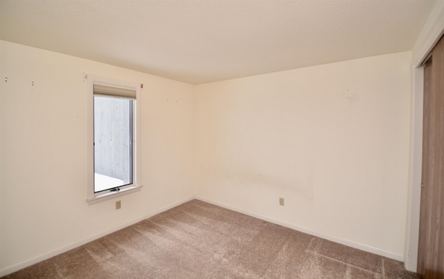 carpeted empty room with baseboards