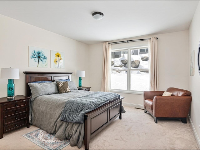 bedroom featuring light carpet and baseboards