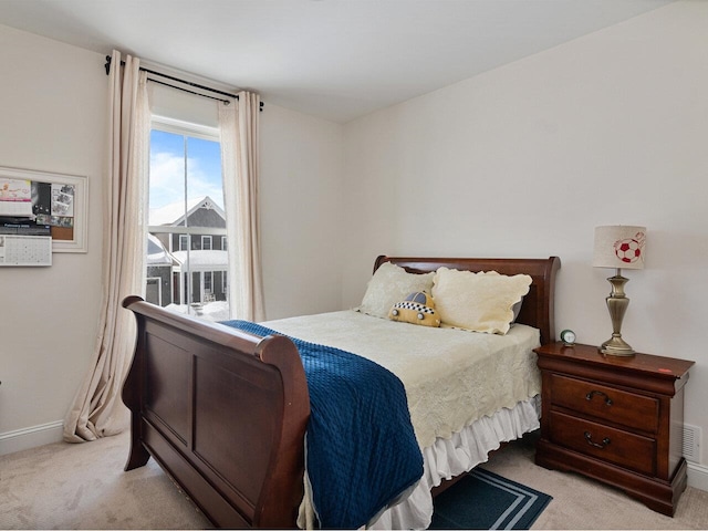 bedroom with light carpet and baseboards