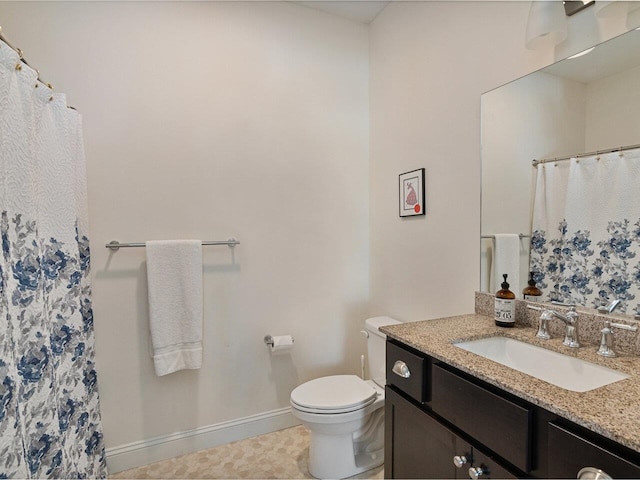 bathroom with a shower with curtain, vanity, toilet, and baseboards