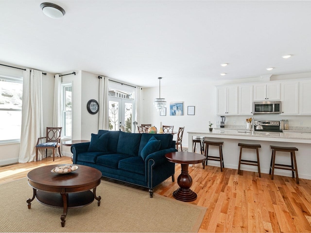 living room featuring recessed lighting, french doors, light wood-style flooring, and baseboards