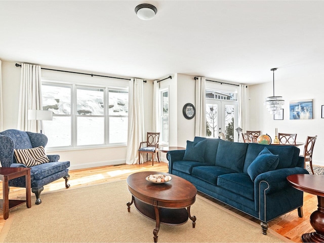 living room featuring french doors, baseboards, and wood finished floors