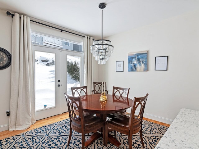 dining room with light wood-style floors, french doors, and baseboards