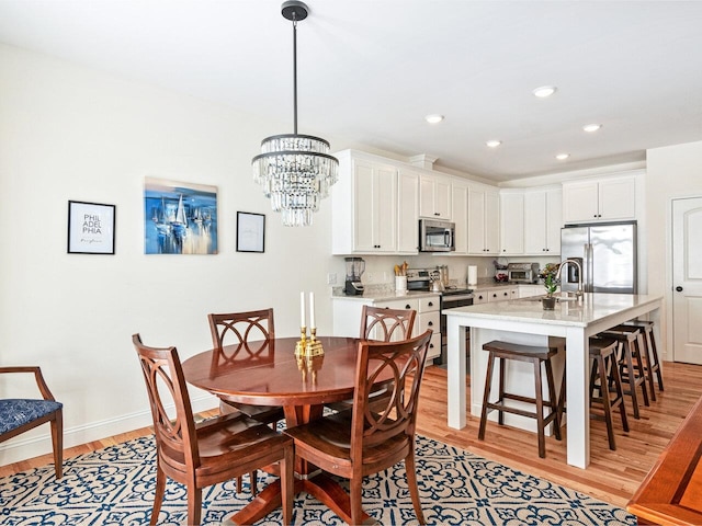 dining area with light wood-style floors, a toaster, baseboards, and recessed lighting