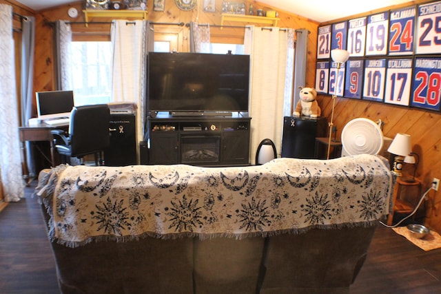 living room with lofted ceiling, wooden walls, and wood finished floors