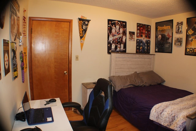 bedroom featuring a textured ceiling and wood finished floors