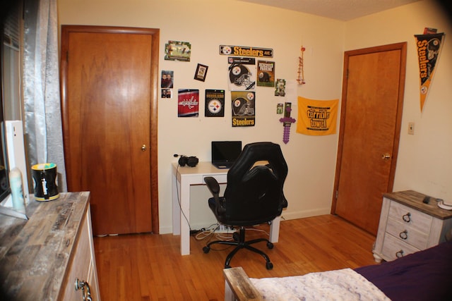 bedroom featuring baseboards and wood finished floors