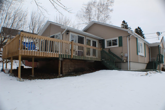 snow covered rear of property featuring a wooden deck