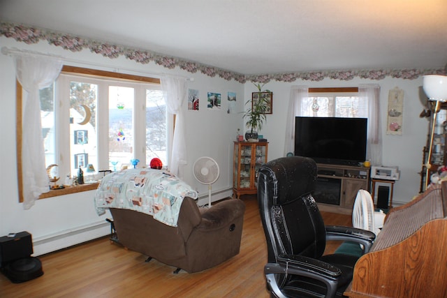 office area featuring a baseboard radiator and wood finished floors