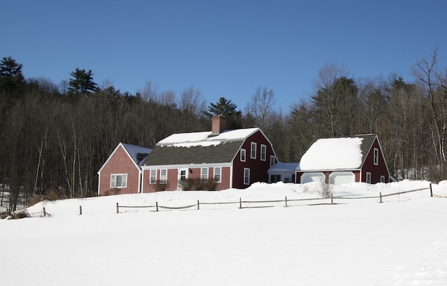 view of front of home with a garage, a gambrel roof, an outdoor structure, and a barn