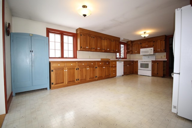 kitchen with white appliances, brown cabinets, light floors, and light countertops