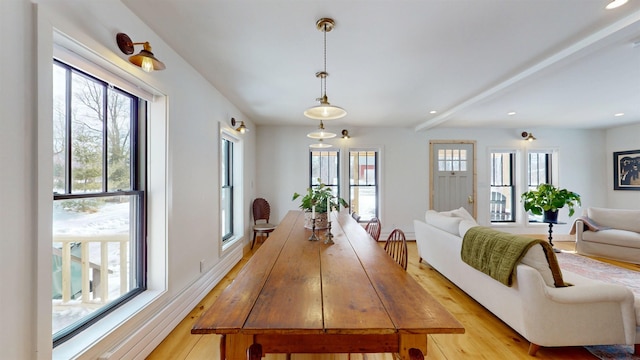 dining space with recessed lighting, light wood-style flooring, a wealth of natural light, and beamed ceiling