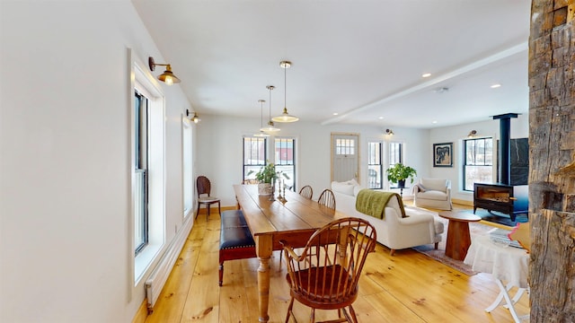 dining area featuring a wood stove, light wood-style floors, and recessed lighting