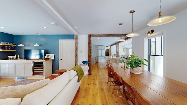 living room featuring light wood-type flooring, beverage cooler, wet bar, and recessed lighting