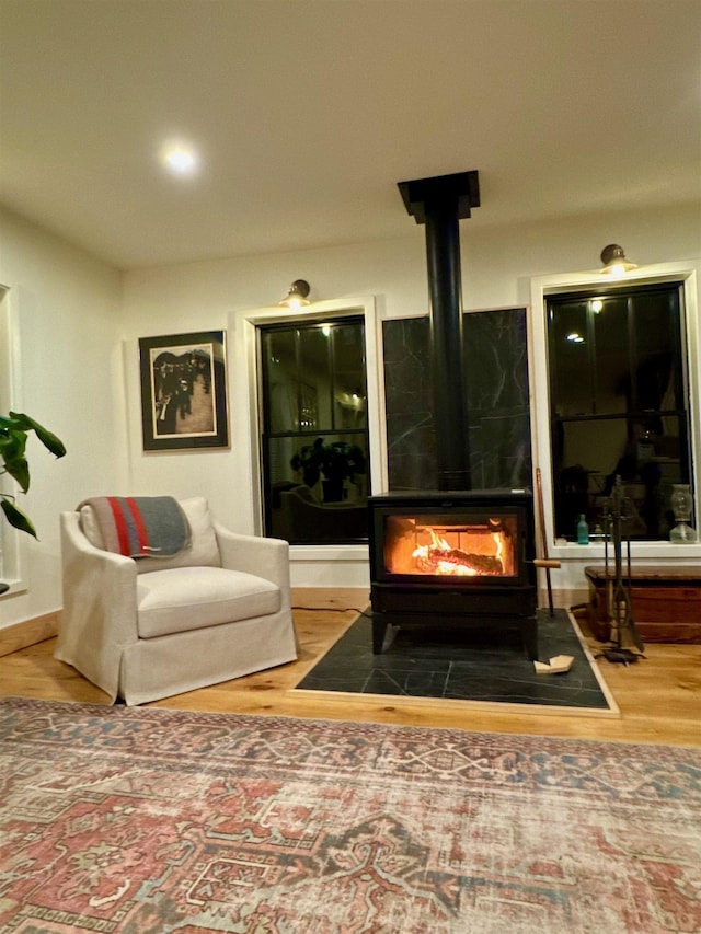 living room with wood finished floors and a wood stove