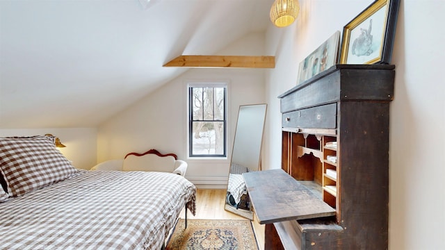 bedroom with vaulted ceiling and wood finished floors