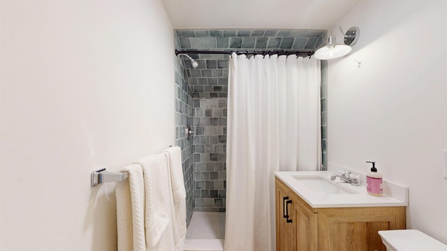 bathroom with toilet, a stall shower, and vanity