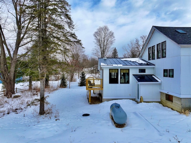 view of snow covered exterior with metal roof and a standing seam roof