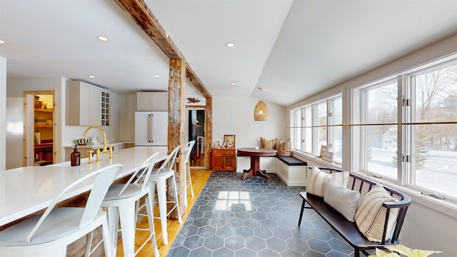 dining space with lofted ceiling with beams, dark tile patterned floors, and recessed lighting