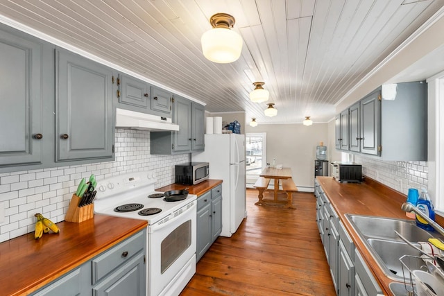 kitchen with white appliances, under cabinet range hood, wooden counters, and gray cabinetry