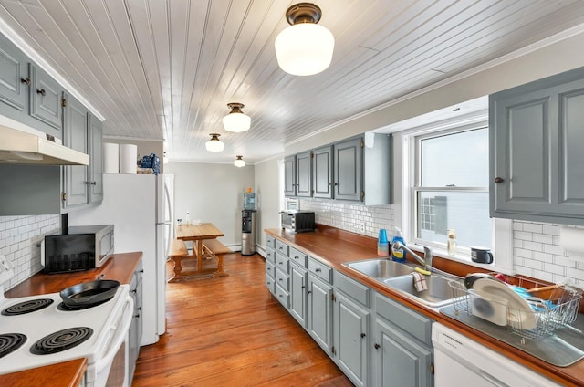 kitchen featuring white appliances, gray cabinets, a sink, and light wood-style flooring