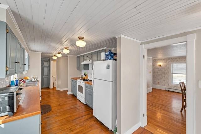 kitchen with white appliances, under cabinet range hood, light wood finished floors, and wallpapered walls