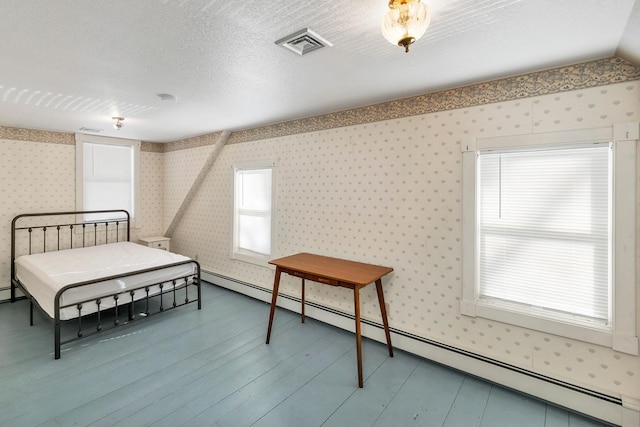 bedroom with wallpapered walls, visible vents, wood finished floors, a textured ceiling, and a baseboard heating unit