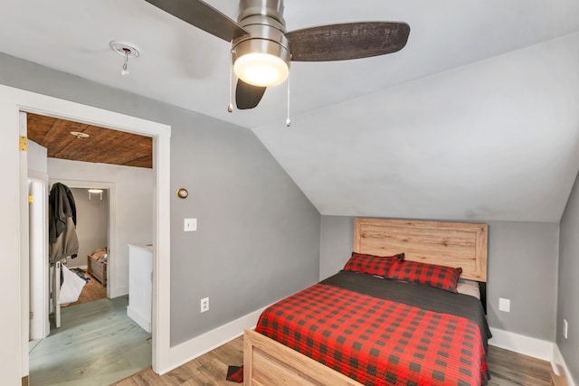 bedroom featuring vaulted ceiling, wood finished floors, a ceiling fan, and baseboards