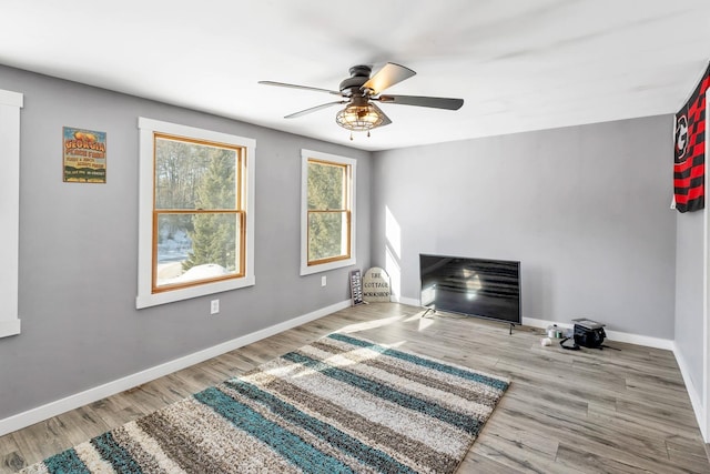 living room with ceiling fan, wood finished floors, and baseboards