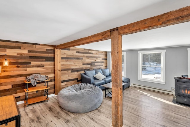 sitting room featuring a wood stove, baseboard heating, beamed ceiling, and wood finished floors