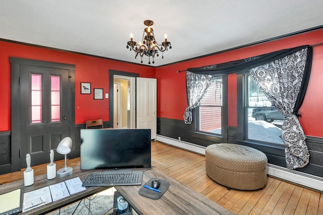 interior space with a baseboard heating unit, wainscoting, hardwood / wood-style floors, and an inviting chandelier