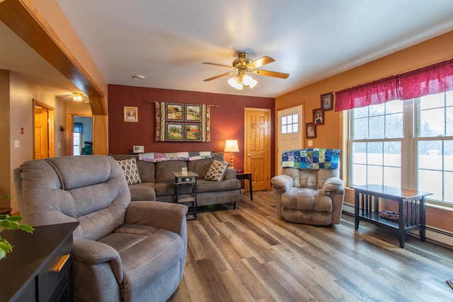 living area with ceiling fan, baseboard heating, and wood finished floors