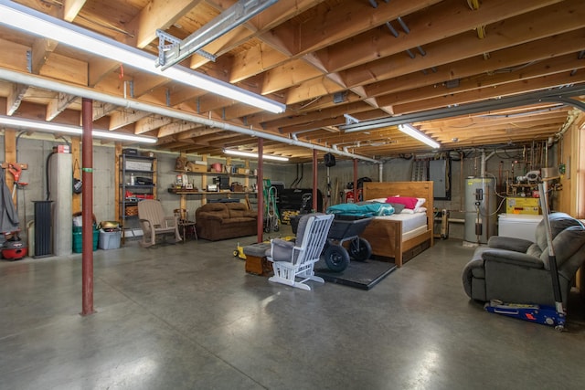 unfinished below grade area featuring electric panel and water heater