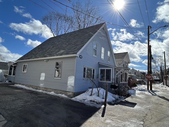 view of snowy exterior with a shingled roof