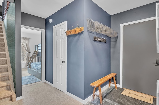 hallway with carpet, baseboards, and stairs