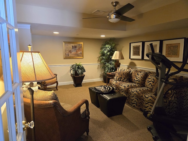 living room featuring carpet floors, recessed lighting, visible vents, a ceiling fan, and wainscoting