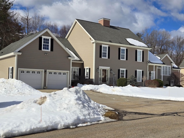 colonial house with a garage and a chimney