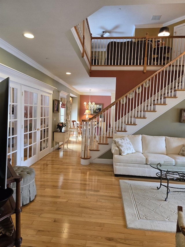 living room with recessed lighting, ceiling fan with notable chandelier, stairway, wood-type flooring, and crown molding