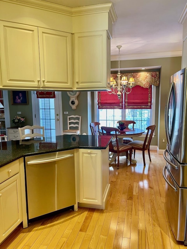 kitchen with crown molding, stainless steel appliances, an inviting chandelier, light wood-style floors, and dark stone counters