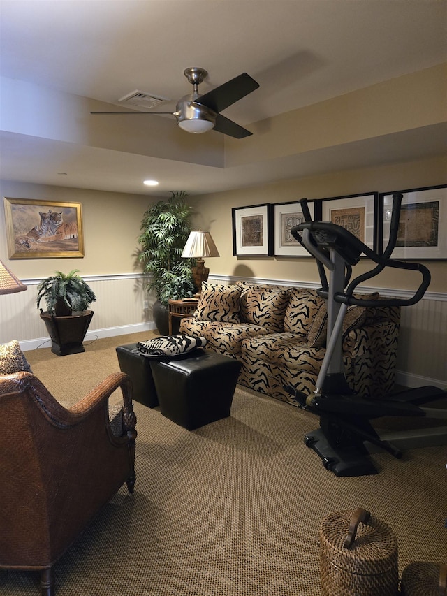 workout room featuring a wainscoted wall, ceiling fan, visible vents, and carpet flooring