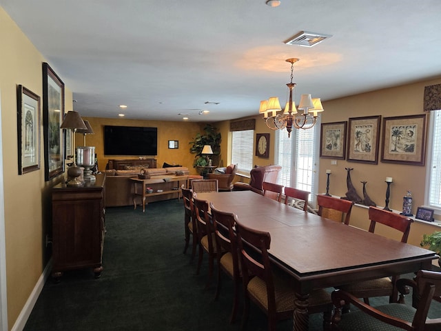 dining space featuring a chandelier, dark colored carpet, visible vents, and baseboards