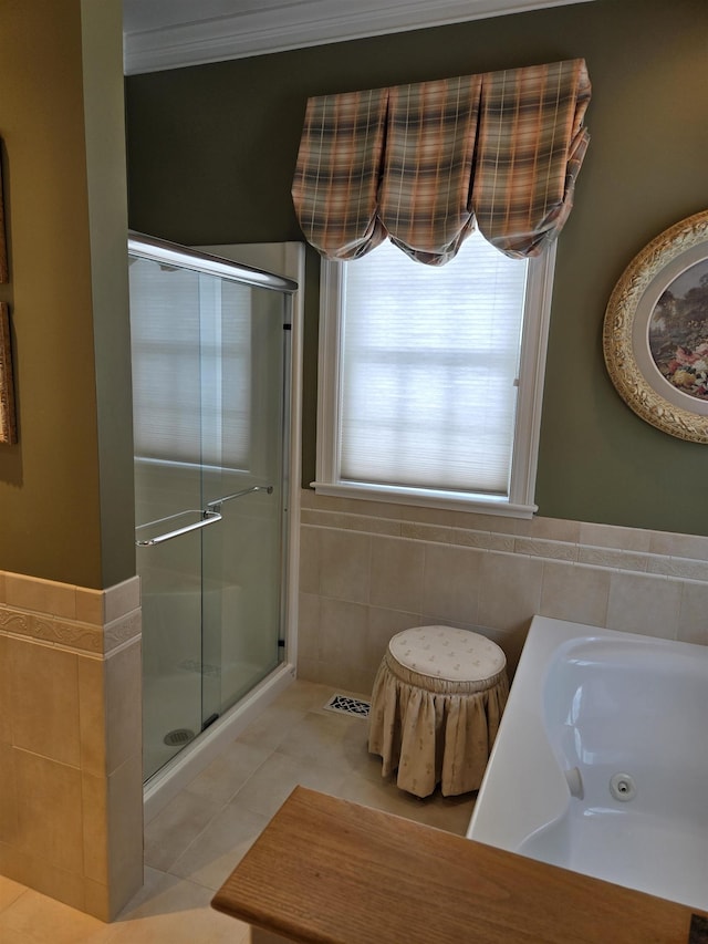 full bath with a stall shower, tile walls, a tub with jets, and tile patterned floors