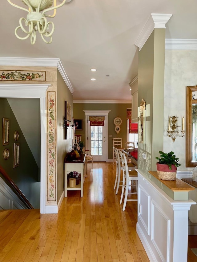 foyer entrance with baseboards, light wood finished floors, and crown molding