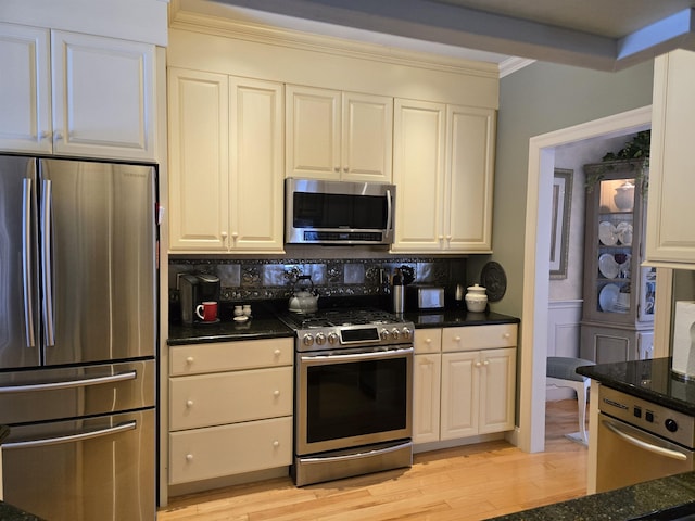 kitchen with light wood-style floors, appliances with stainless steel finishes, decorative backsplash, and crown molding