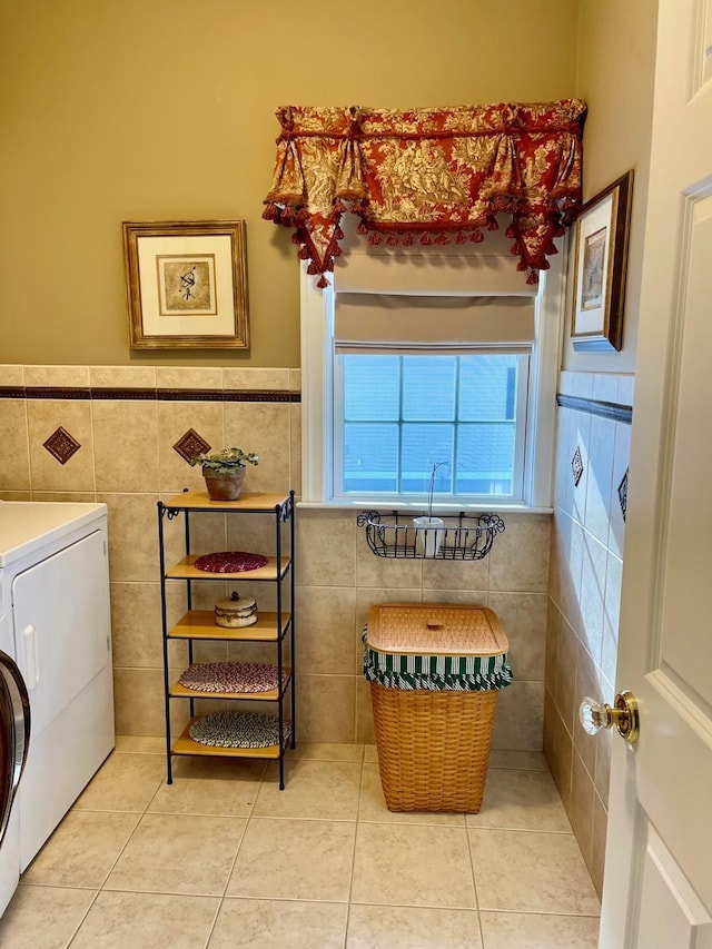 washroom featuring light tile patterned floors, laundry area, tile walls, wainscoting, and washer / clothes dryer